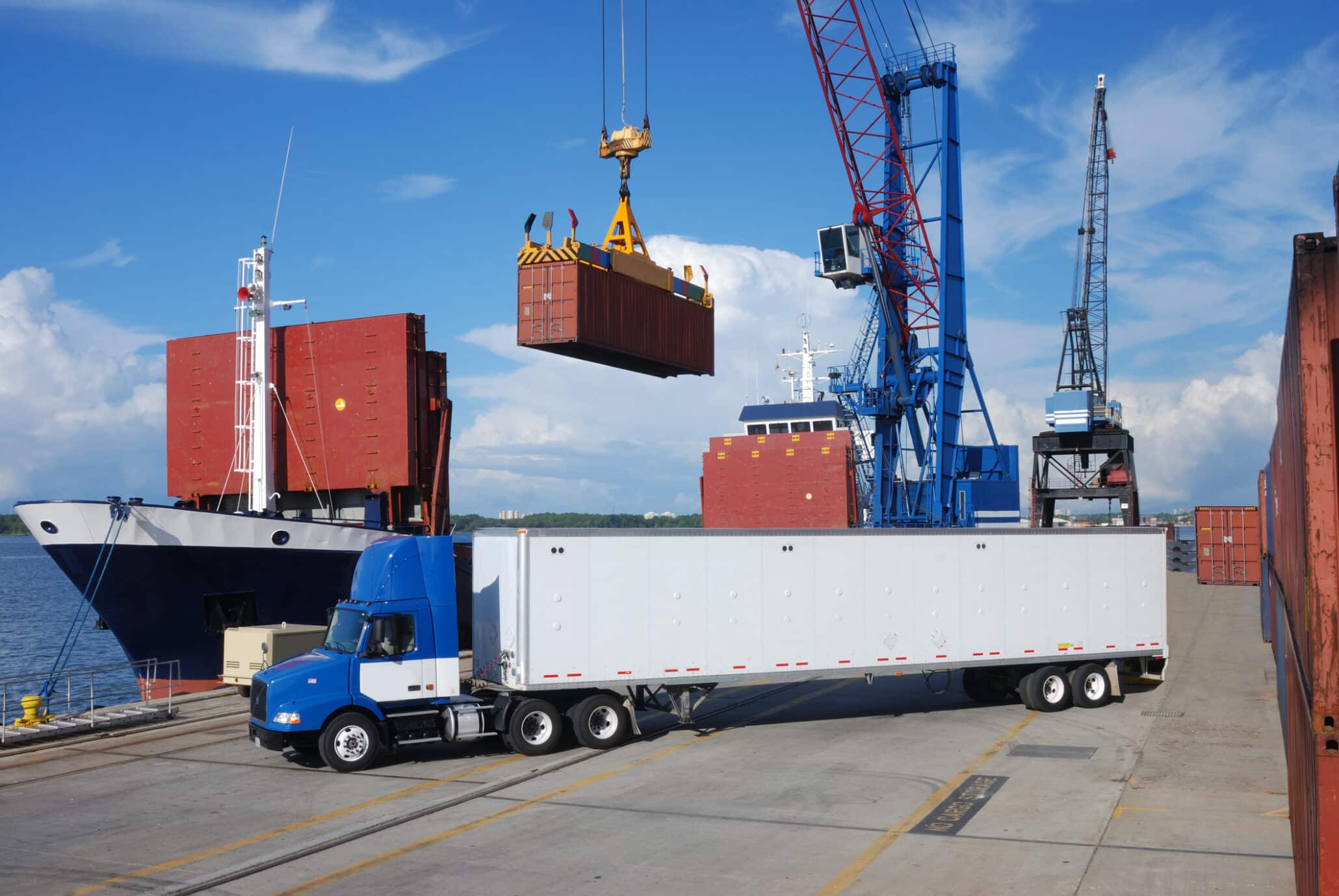 Blick auf den Hafen Hamburg mit Kran und LKW bei der Verladung von Containern