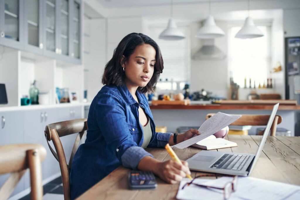 Junge Frau am Laptop bei einer kaufmännischen Tätigkeit während ihres Zeitarbeiteinsatzes bei TREND-JOB